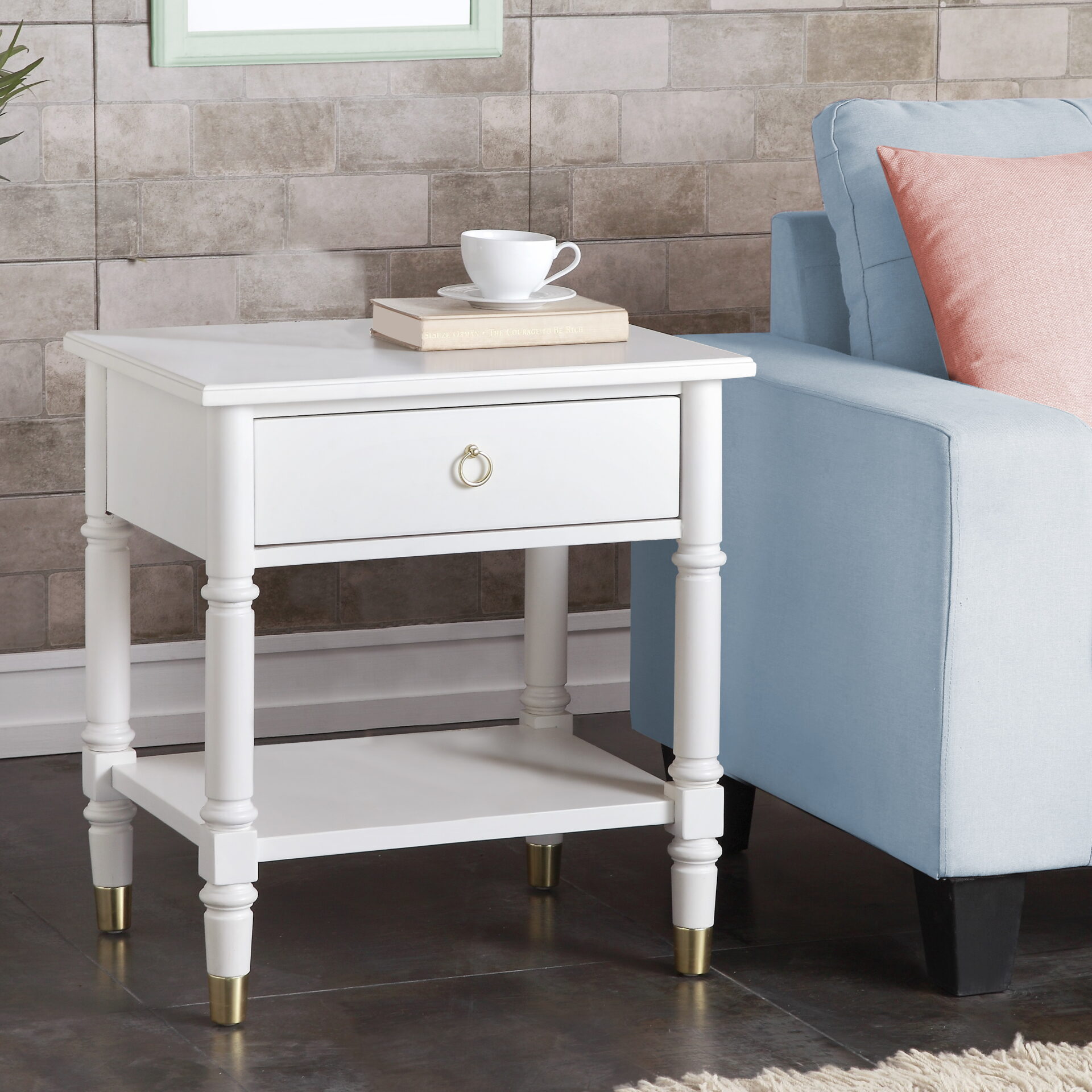 A white side table with a book and a cup